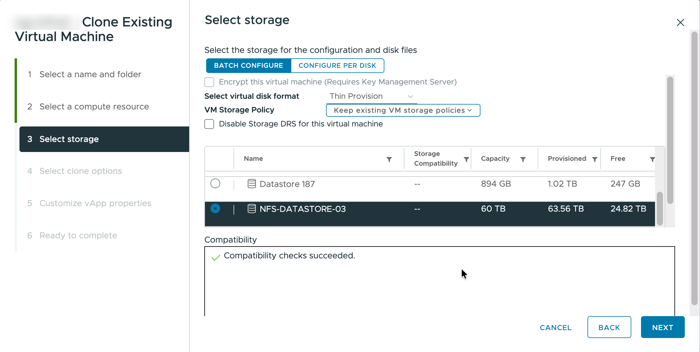 Clonar máquina virtual existente – Selecionar armazenamento Etapa Selecionar armazenamento do assistente de clonagem com as opções Manter políticas de armazenamento da VM existente e NFS-DATASTORE-03 selecionadas